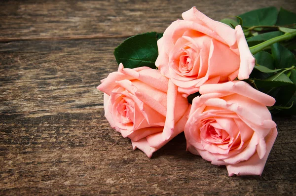 Ahşap masanın üzerinde pembe güller
