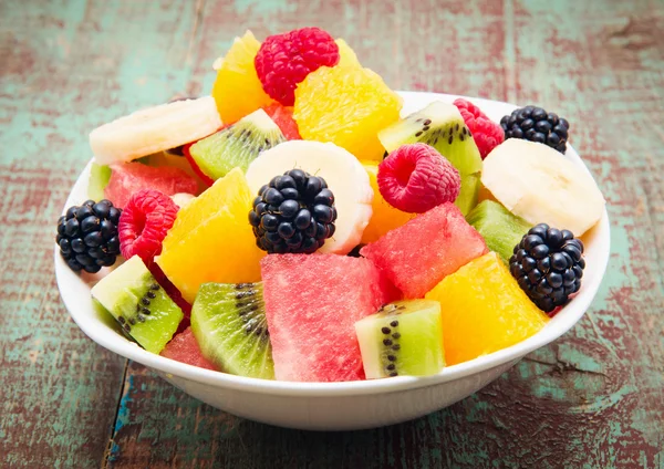 Frischer gesunder Obstsalat auf Holzgrund — Stockfoto