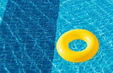 Sarı havuz yüzer, halka yüzer ferahlatıcı mavi bir yüzme havuzunda
