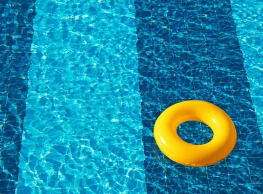 Sarı havuz yüzer, halka yüzer ferahlatıcı mavi bir yüzme havuzunda