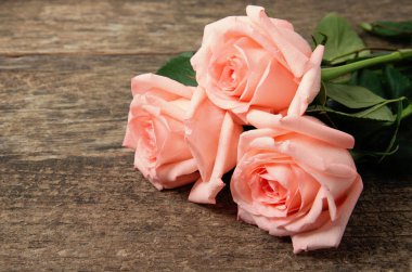 Ahşap masanın üzerinde pembe güller