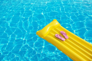 Yaz tatili geçmişi. Şişme şişme yatak, parmak arası terlik ve yüzme havuzunda şapka..
