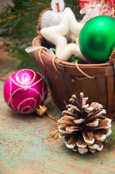 Рождественская корзина с игрушками на деревянном фоне — стоковое фото