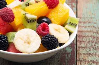 Tahta arka planda taze sağlıklı meyve salatası