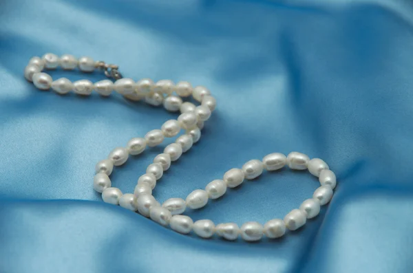 Pearls a necklace on a silk fabric — Stock Photo, Image