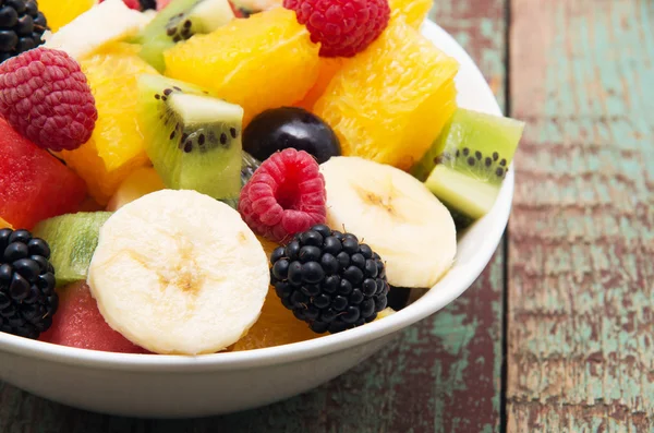 Frischer gesunder Obstsalat auf Holzgrund — Stockfoto