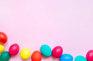 Pembe arka planda renkli paskalya yumurtaları ve fotokopi alanı. Paskalya arkaplanı