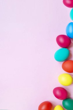 Pembe arka planda renkli paskalya yumurtaları ve fotokopi alanı. Paskalya arkaplanı
