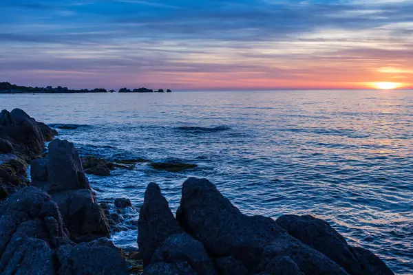 Romántico atardecer en la playa rocosa — Foto de Stock