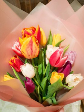 Pakette bir buket lale var. Çok renkli bir buket. Kadınlar günü ya da anneler günü için bir hediye. Ekran için arkaplan.