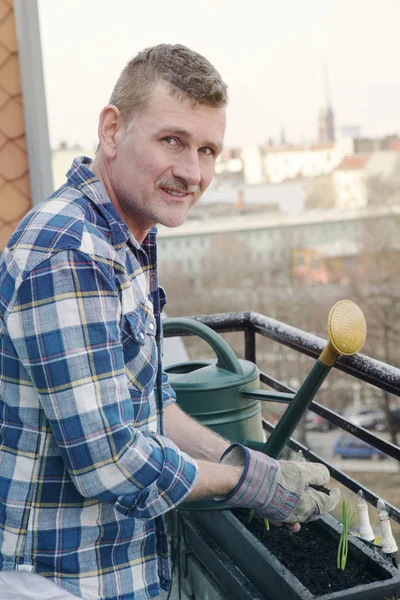 Man working plants on balcony — Stock Photo, Image