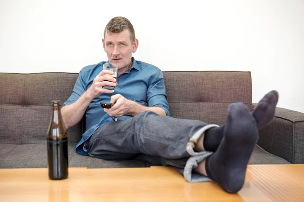 Man sitting on couch and watching tv — Stock Photo, Image