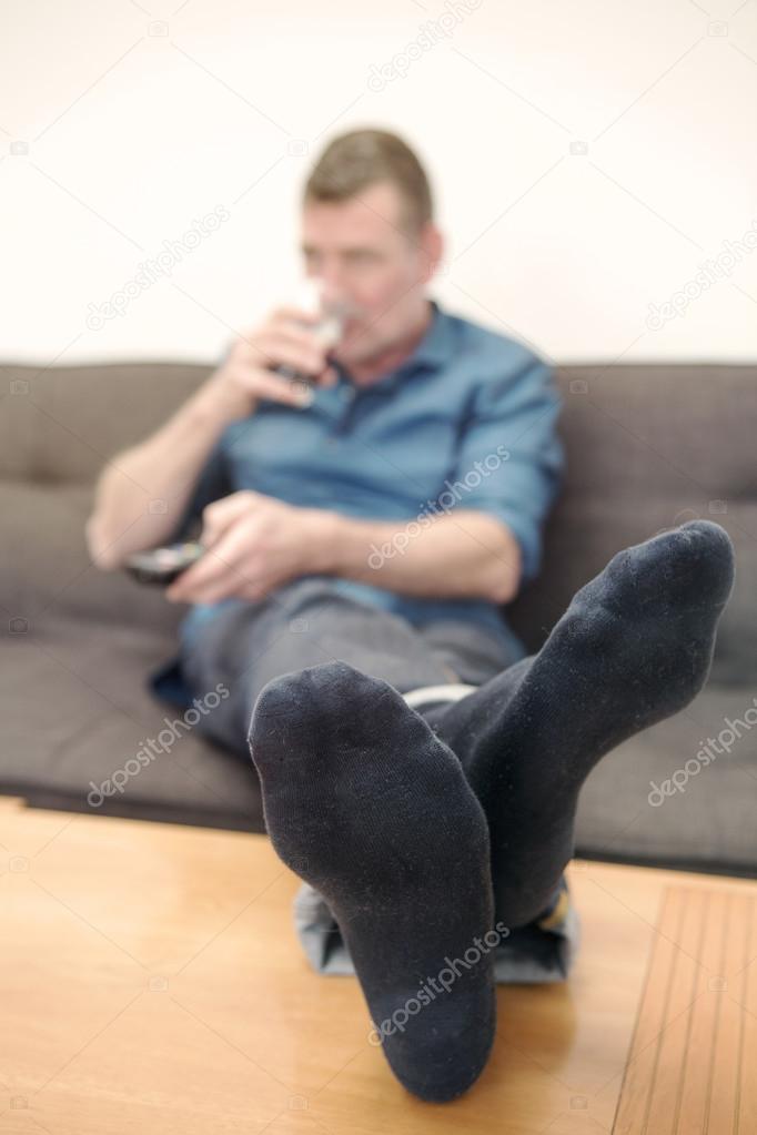 man sitting on couch and watching tv