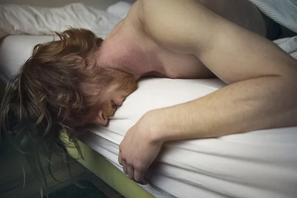 Roodharige man in bed op zoek ziek liggen — Stockfoto