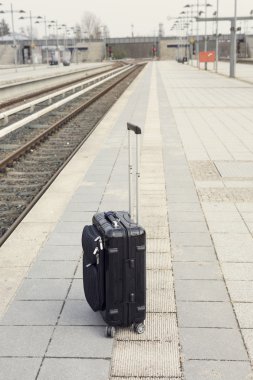 bir trainstation platformu üzerinde siyah bavul