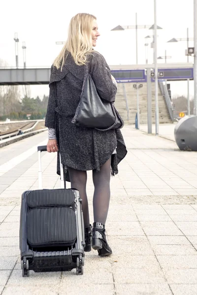 Женщина ходит с чемоданом на вокзале — стоковое фото