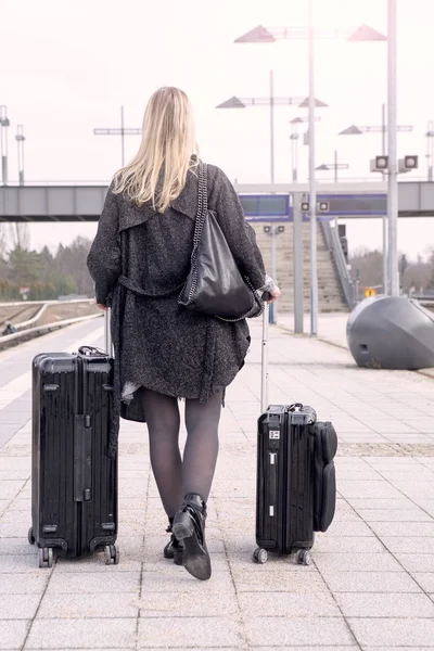 Женщина ходит с чемоданами на вокзале — стоковое фото