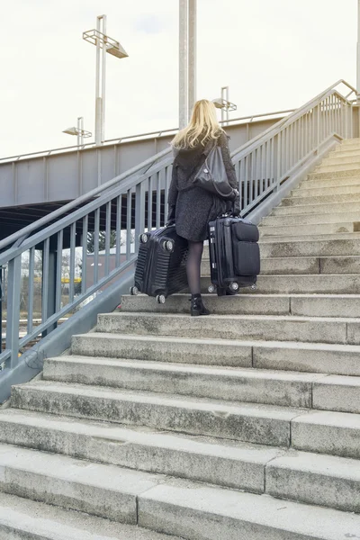 Femme avec valises marchant dans les escaliers — Photo
