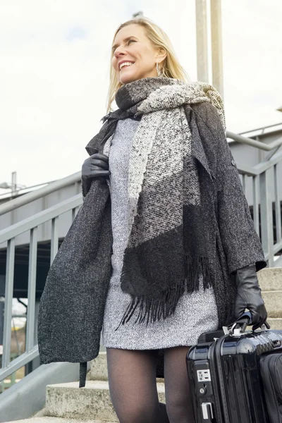 Femme avec valise descendant les escaliers à la gare — Photo