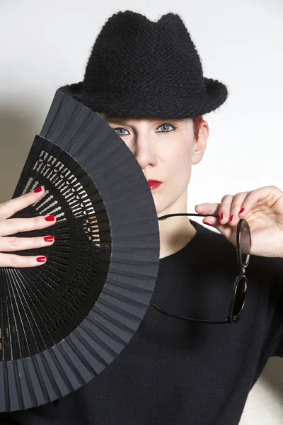 Portret van een vrouw met zwarte hoed en ventilator — Stockfoto
