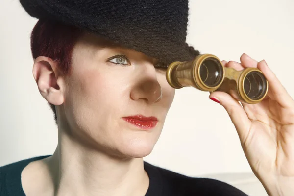 Woman with hat looking through binoculars — Stock Photo, Image