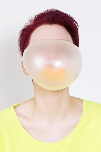 Donna con grande bolla gialla di gomma da masticare — Foto Stock