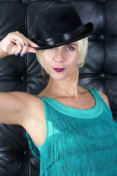 Blond woman in green dress with black hat Stock Photo
