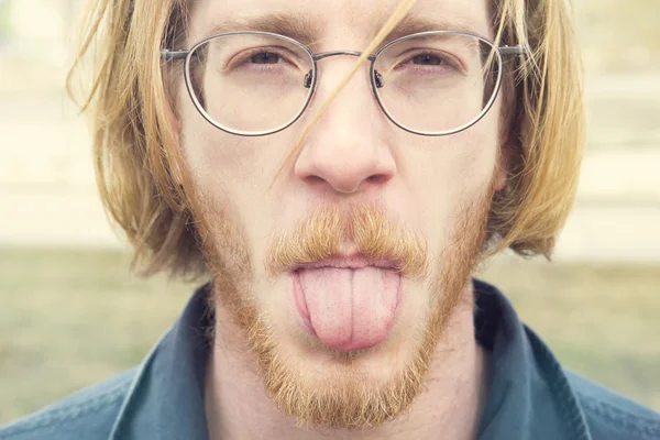 Young man with red hair sticking out his tongue — Stock Photo, Image