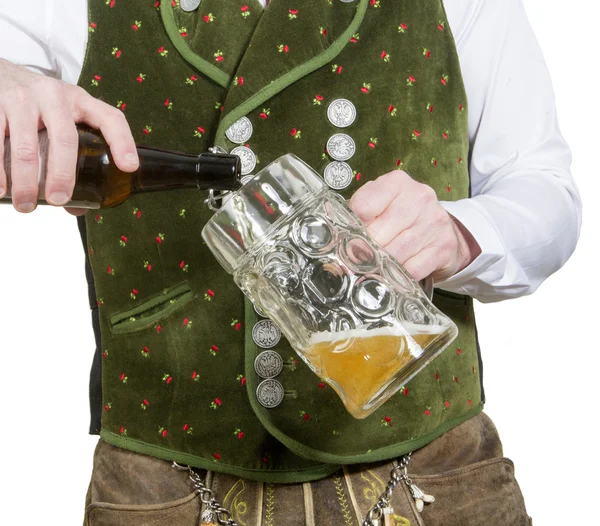 Closeup of bavarian man pouring beer in glass — Stock Photo, Image