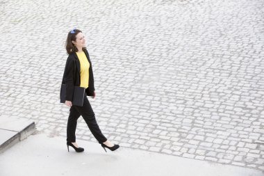 yürüyüş ve bir kitap tutan genç kadın