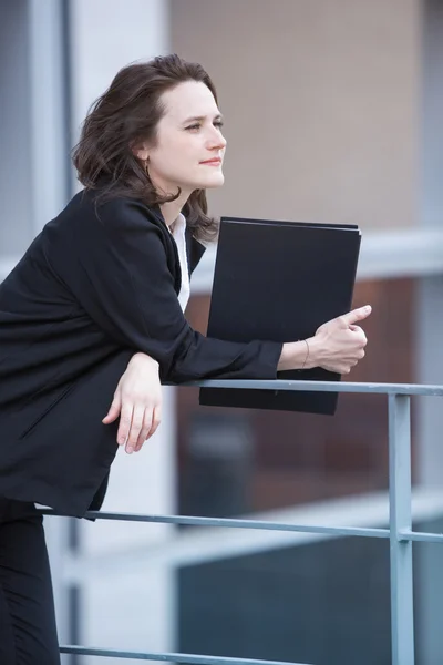 Young woman standing and holding a book — Stock Photo, Image