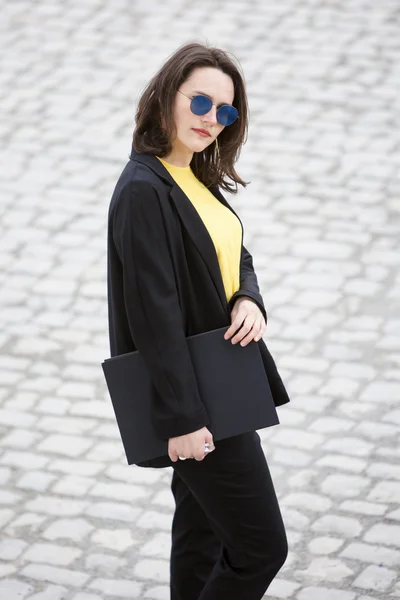 Joven mujer de pie y sosteniendo un libro — Foto de Stock