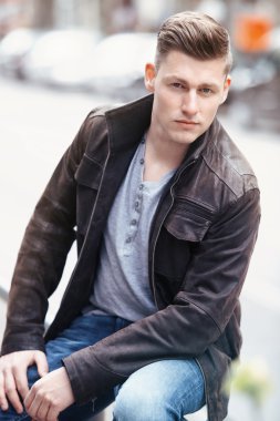 young blond man sitting outside