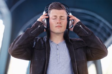 sokakta duran kulaklık ile genç adam