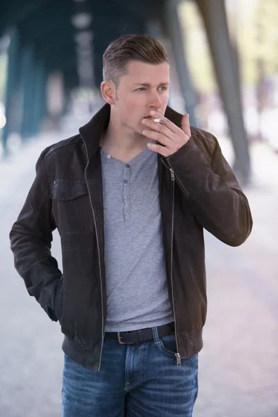 Uomo fumare una sigaretta in strada — Foto Stock