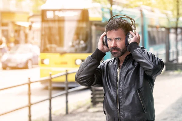 Junger Mann mit Kopfhörern steht auf der Straße — Stockfoto