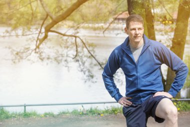 adam ayakta açık havada, tezgah ve strechting olduğunu