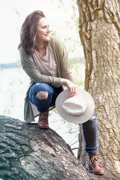 Joven mujer de pie en un árbol junto al agua —  Fotos de Stock