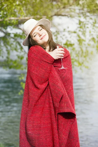 Femme enveloppée dans une couverture tenant une coupe de champagne à l'extérieur — Photo