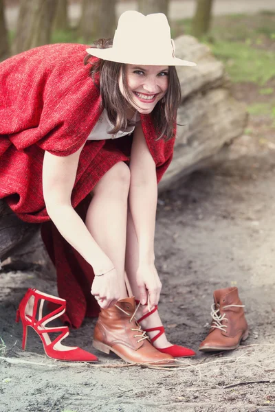 Frau sitzt auf Baum und wechselt ihre Schuhe — Stockfoto