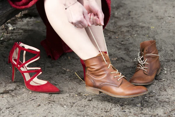 Primer plano de la mujer cambiando sus tacones altos para botas — Foto de Stock