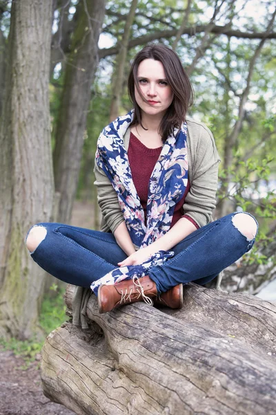 Retrato de una joven sentada en un árbol —  Fotos de Stock