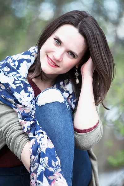 Portrait de jeune femme assise dans le parc — Photo