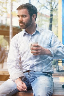 dışında oturan ve kahve içme yakışıklı adam