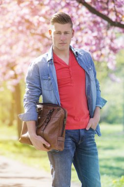 genç adam parkta bir çanta ayakta tutan