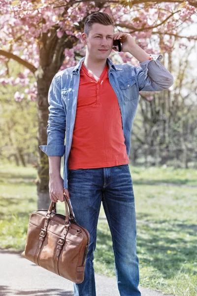 Young man in park talking on phone — Stock Photo, Image