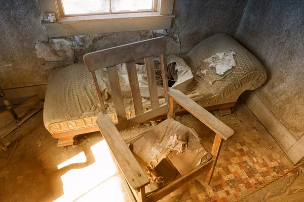 Cadeira velha abandonada e sofá dentro de casa — Fotografia de Stock