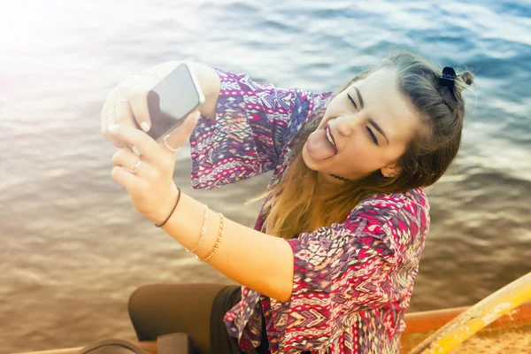 Joven mujer tomando una selfie y sacando su lengua — Foto de Stock