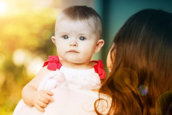 Bruneta žena držící roztomilé dítě — Stock fotografie