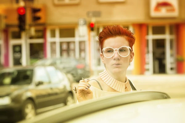 Γυναίκα με τα κόκκινα μαλλιά στέκεται στο δρόμο και το κάπνισμα — Φωτογραφία Αρχείου